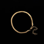 Pulsera Egipcia dorada con cierre y cadena extensora sobre fondo negro
